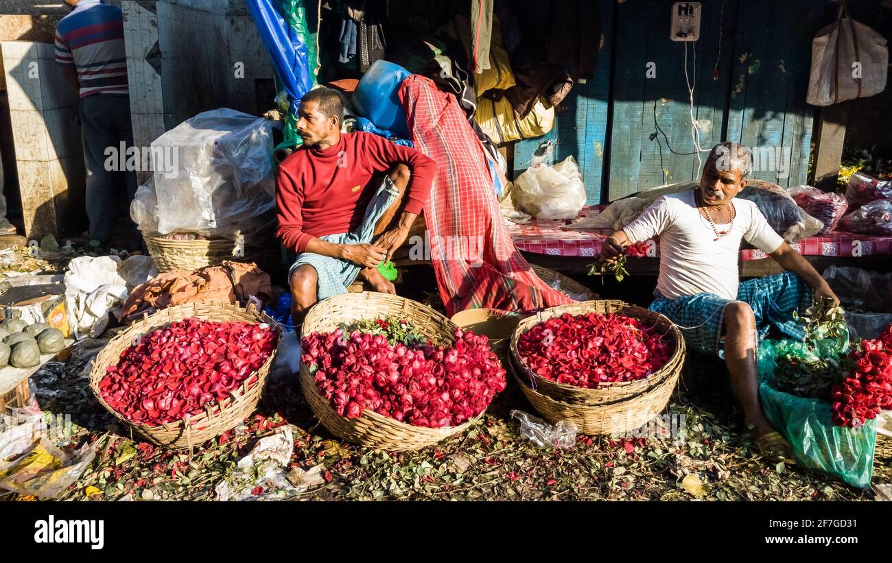 Kolkata, Bengala Occidentale, India - Gennaio 2018: Venditori di strada che vendono rose colorate e fiori in cestini nell'antico mercato dei fiori di Mullick Ghat Foto Stock