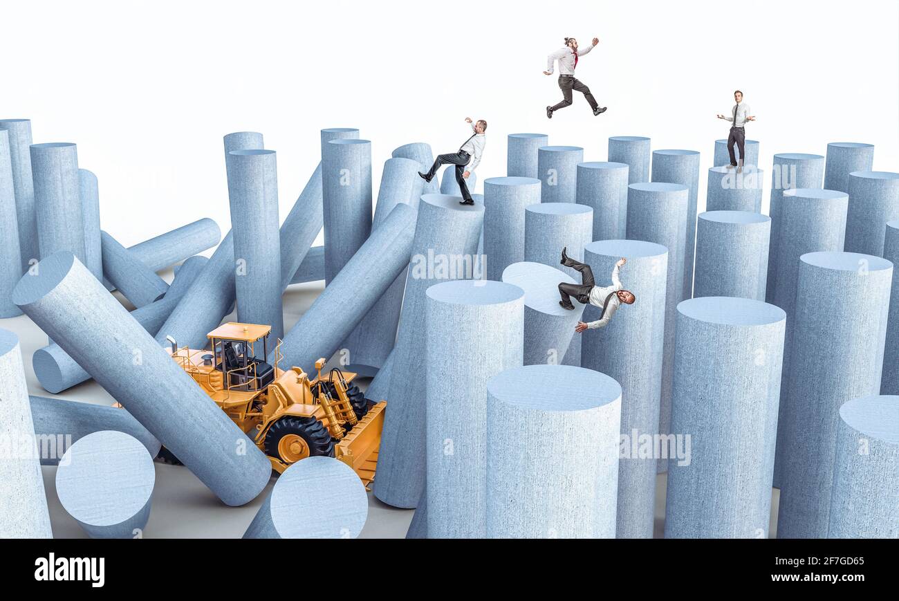 il bulldozer distrugge le torri con gli uomini d'affari su di loro, concetto di instabilità e rischio nel mondo del lavoro. Foto Stock