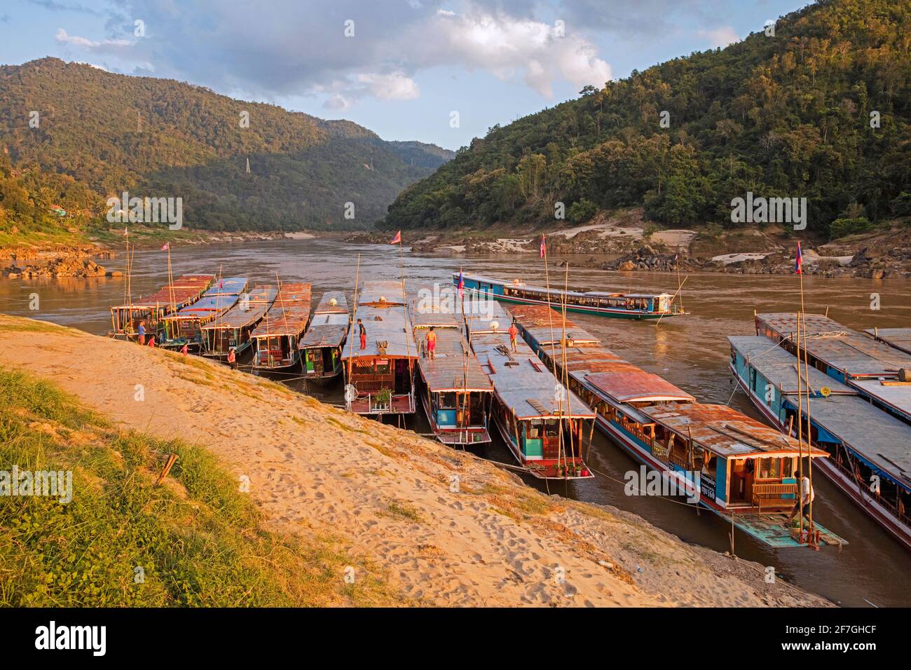 Slowboats / Slow boats per crociere fluviali a Luang Phabang / Luang Prabang / Louangphabang sul fiume Mekong al tramonto, Laos Foto Stock