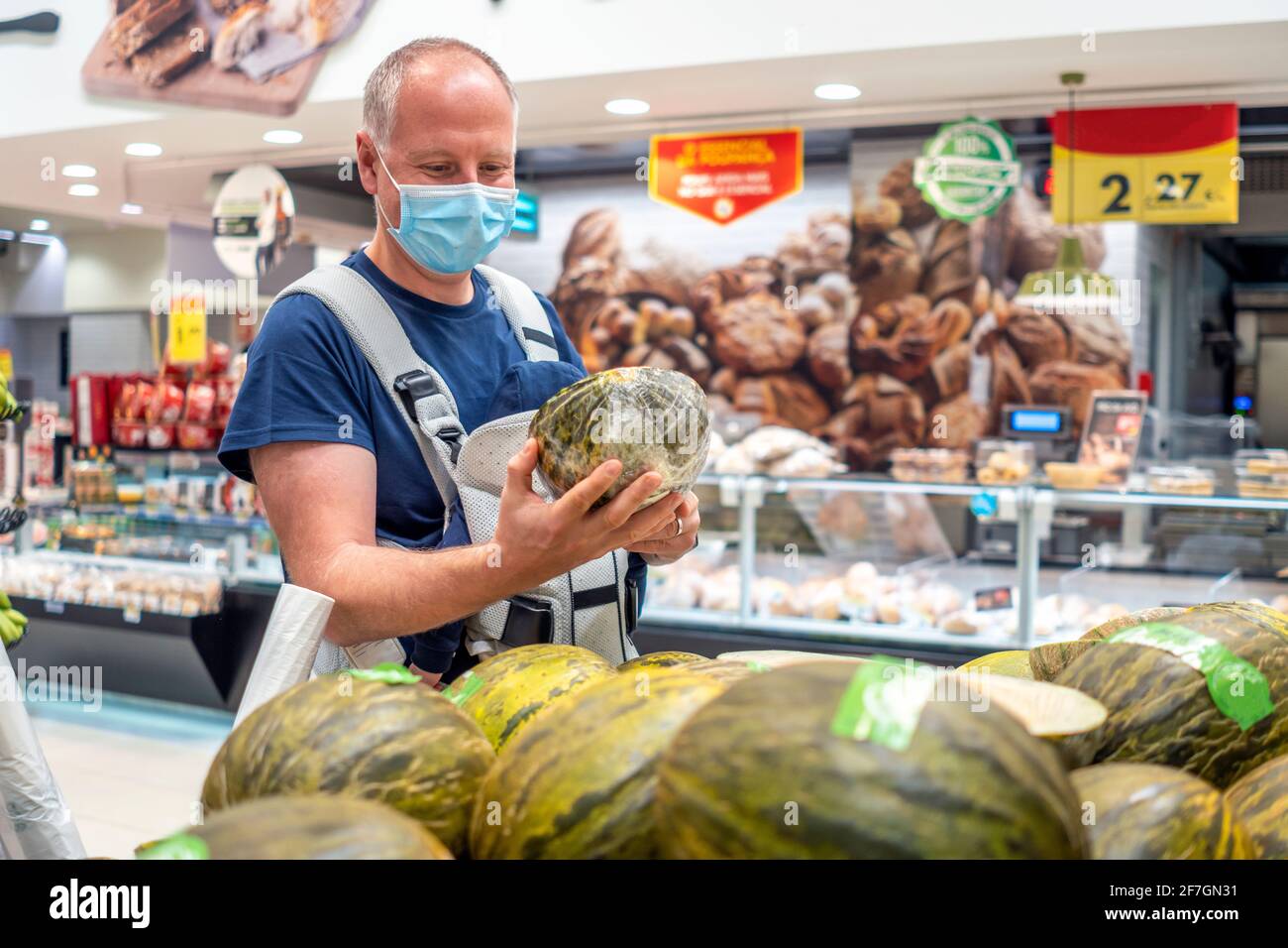 Un uomo che indossa una maschera a fare shopping Foto Stock