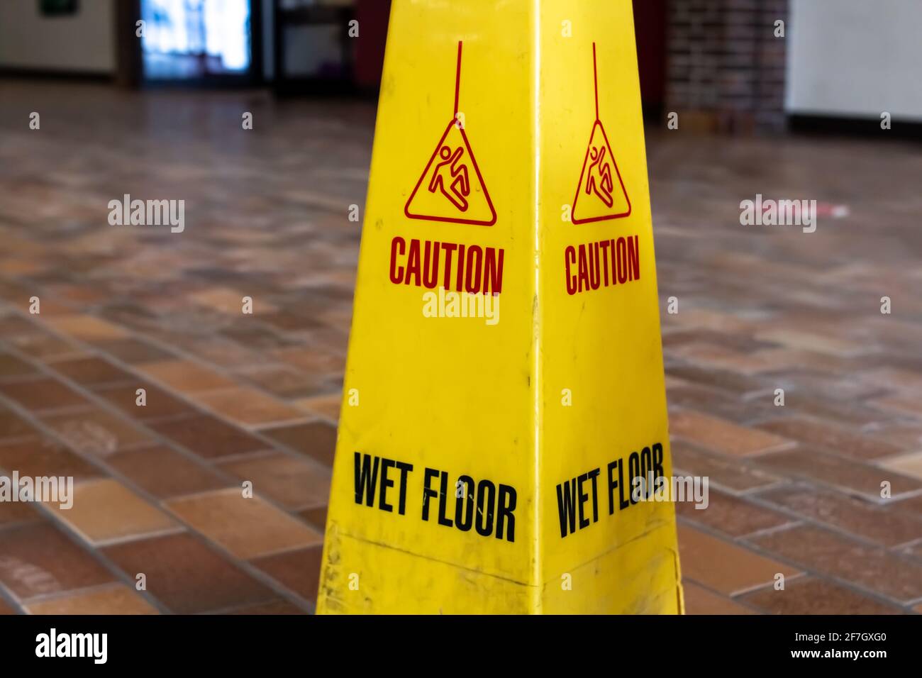 Un cartello giallo sporco a quattro lati bagnato su un terreno di piastrelle polverose a Londra, Ontario Canada, febbraio 2021. Foto Stock