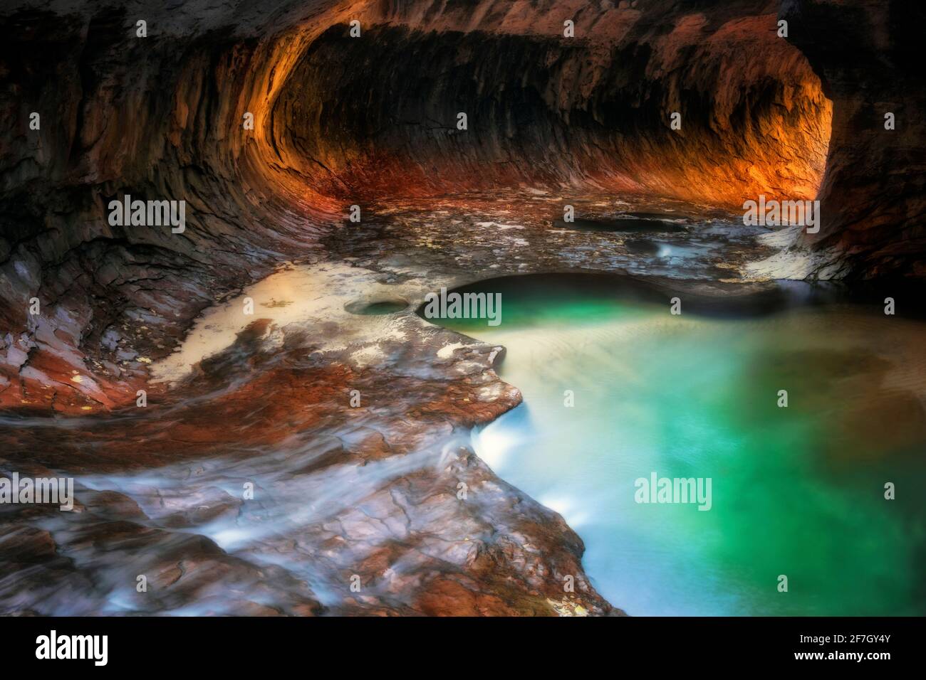 La luce riflettente illumina le pareti del canyon a labirinto con le sue piscine color smeraldo nel Parco Nazionale di Zion. Foto Stock
