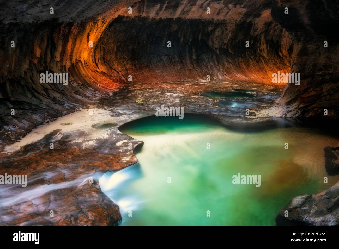 La luce riflettente illumina le pareti del canyon a labirinto con le sue piscine color smeraldo nel Parco Nazionale di Zion. Foto Stock
