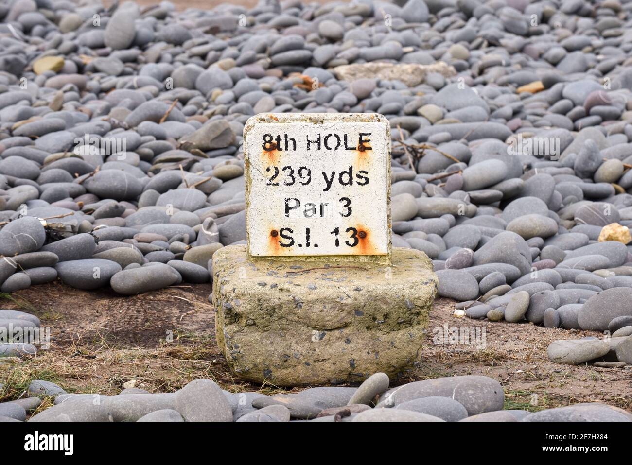 Il segno del contrassegno di golf su un tee che è stato lavato nel mare Foto Stock