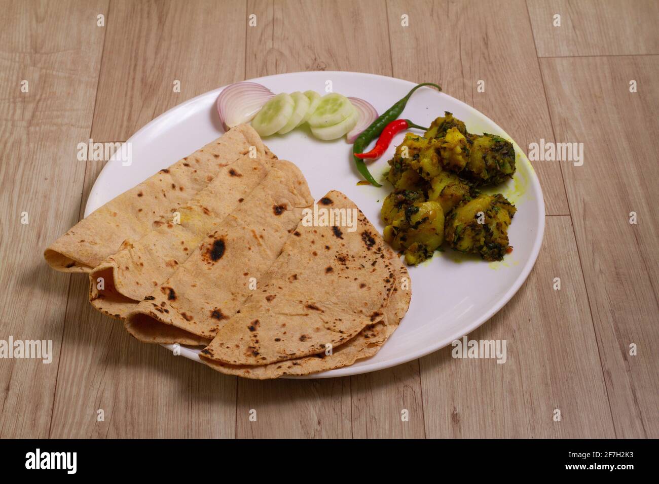 Jeera Aloo e chapati - patate aromatizzate con Cumin is un accompagnamento caldo e speziato per il curry può essere mangiato come spuntino con pane, parata, cappati Foto Stock