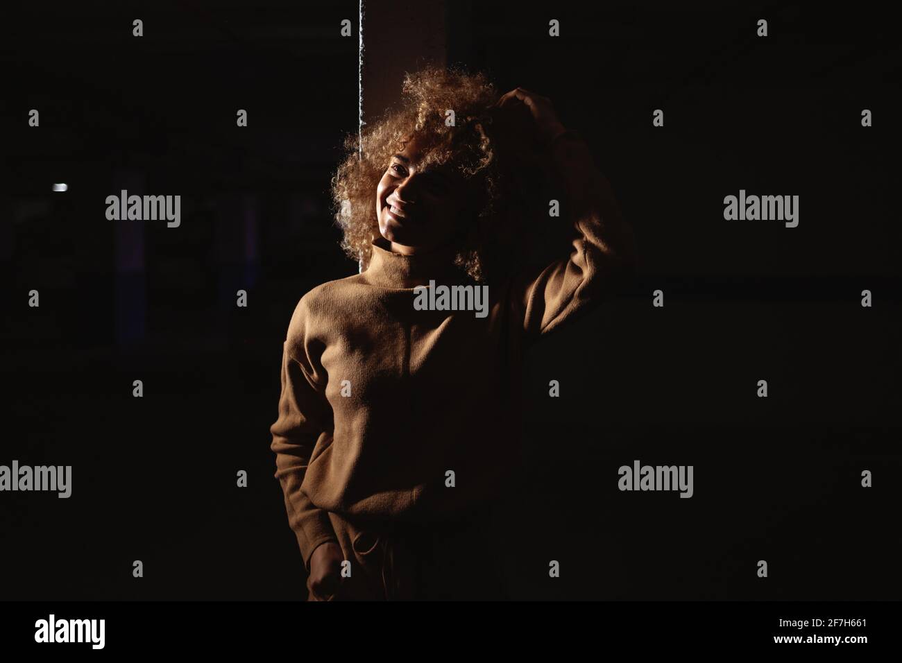 Misto razza rap ragazza in piedi in ombra in garage sotterraneo. Foto Stock