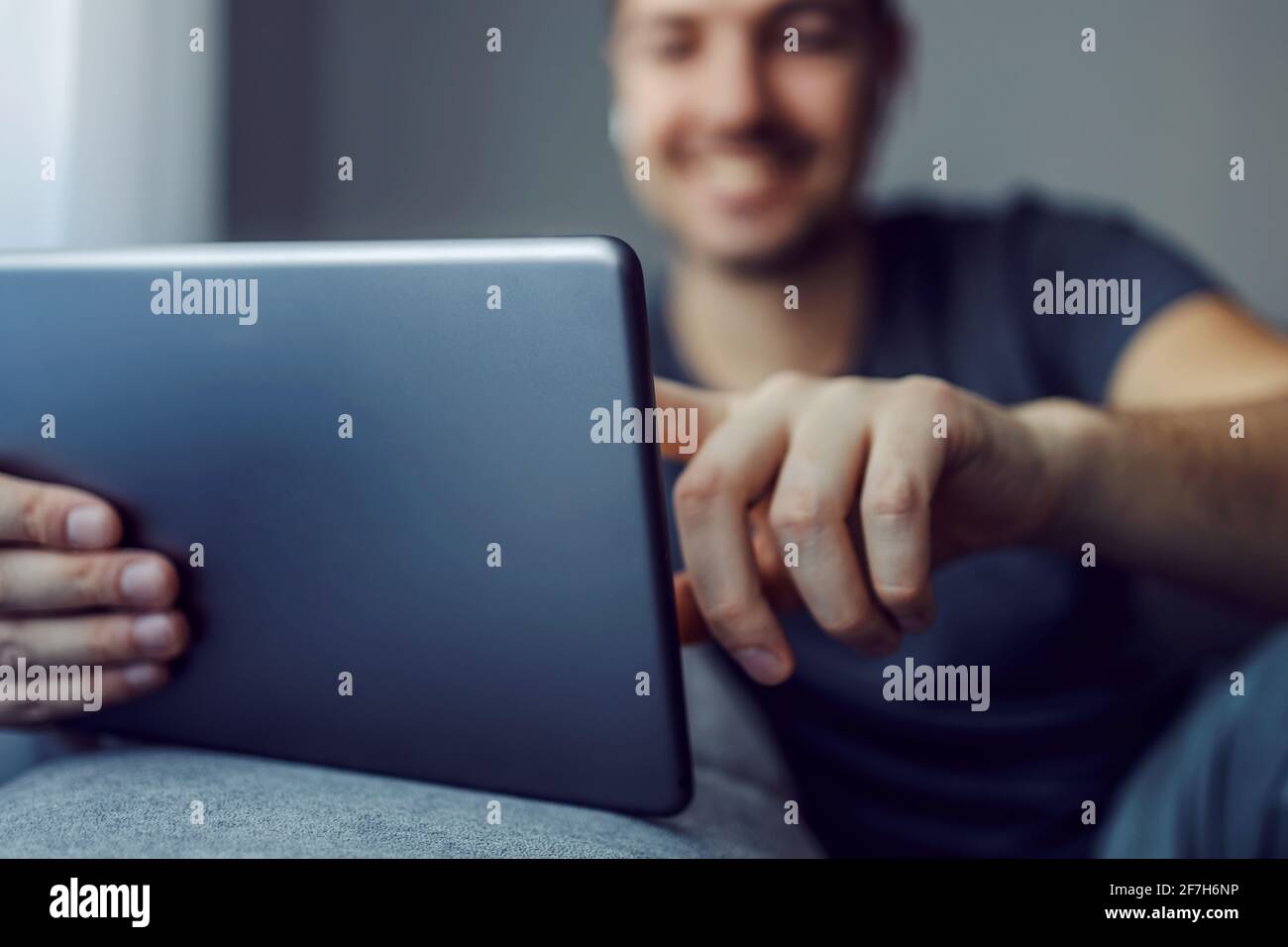 Uomini mani che tengono mobile nel soggiorno dell'appartamento. Spazio di copia vuoto per testo pubblicitario social media online, verifica digitale Foto Stock