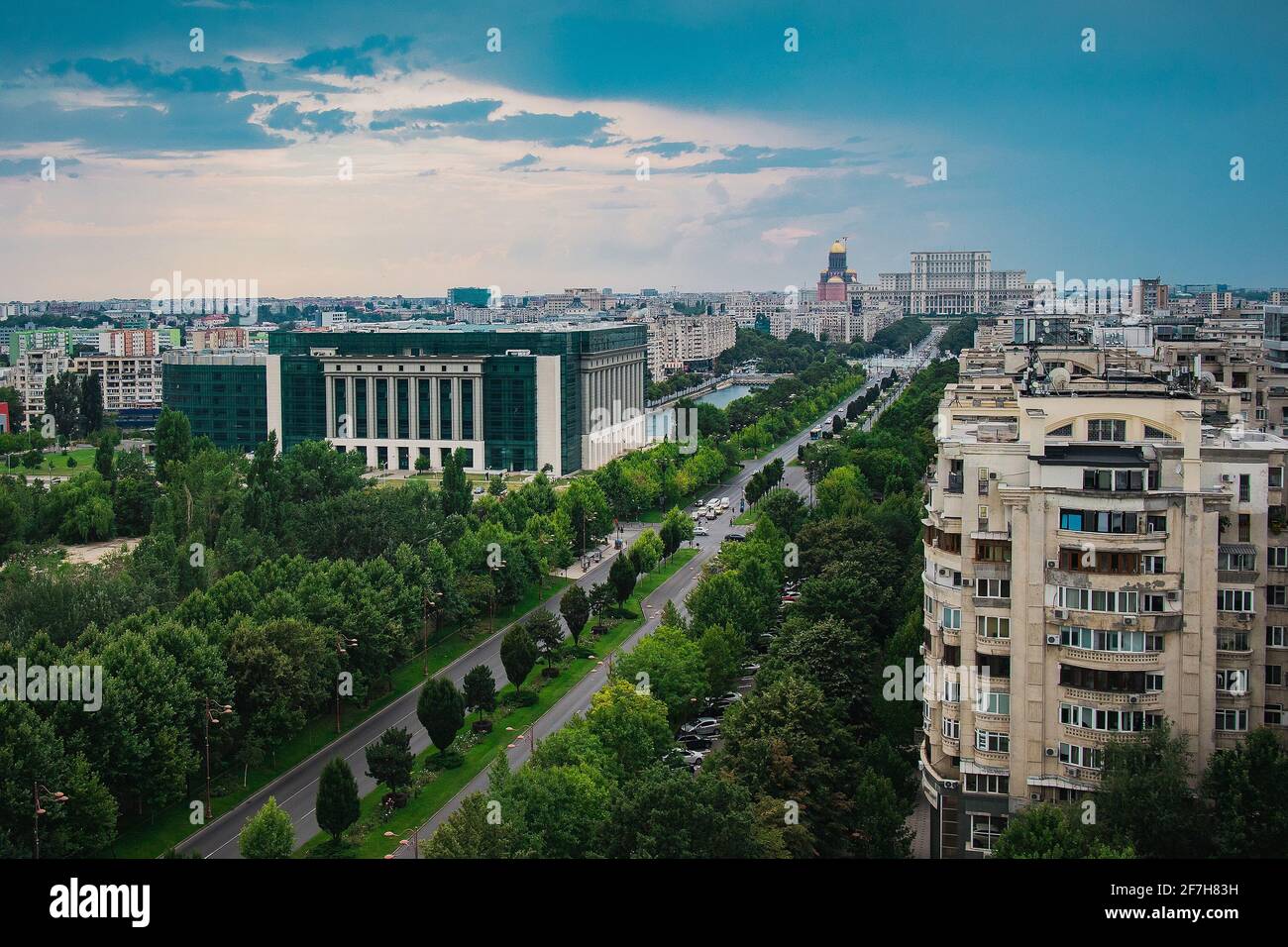 Sede del parlamento rumeno, enorme edificio nel centro di Bucarest, Romania in una giornata estiva nuvolosa. Vista sul viale che guarda verso il parlamento Foto Stock