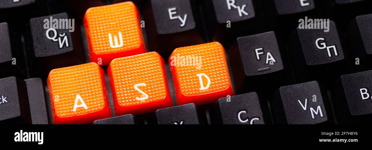 Tasti freccia arancione su una tastiera nera, pulsanti su, giù, sinistra, destra sulla tastiera di un computer di gioco. Foto Stock