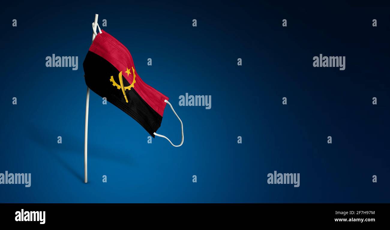 Maschera Angola su sfondo blu scuro. Bandiera ondulata dell'Angola dipinta su maschera medica sul palo. Flag di attacco del virus. Concetto della bandiera della lotta agai Foto Stock