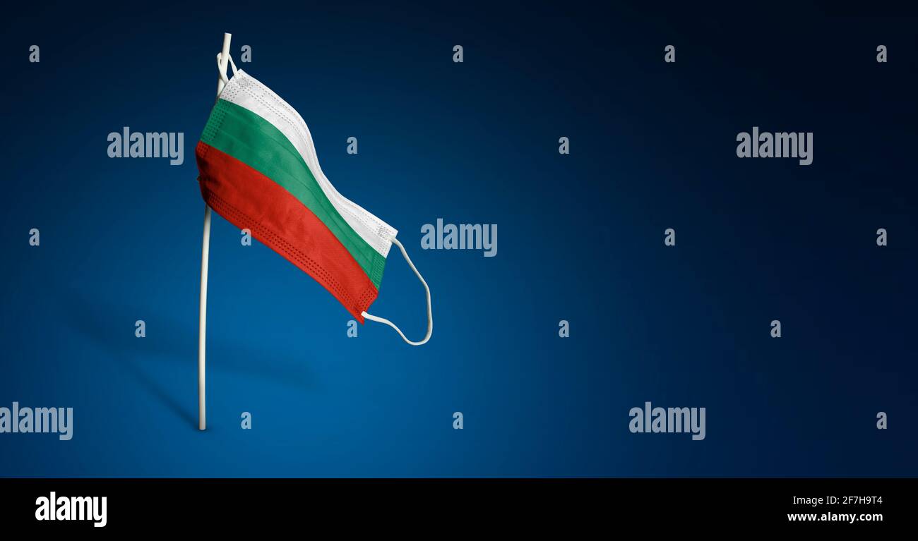 Maschera Bulgaria su sfondo blu scuro. Bandiera ondulata della Bulgaria dipinta su maschera medica sul palo. Flag di attacco del virus. Concetto della bandiera della lotta Foto Stock