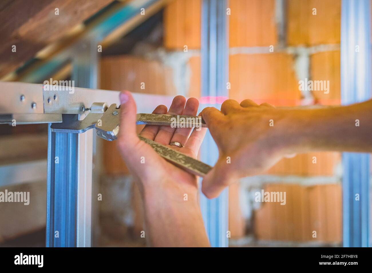 Pinze per prigionieri in gesso per cartongesso in azione. Una persona che  tiene in mano e utilizza la pinza a crimpare per prigionieri mentre  costruisce una costruzione in metallo a secco in