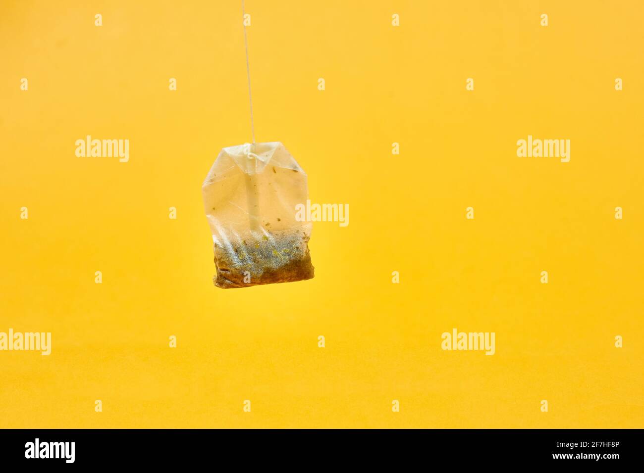sacchetto di tè usato su sfondo giallo Foto Stock