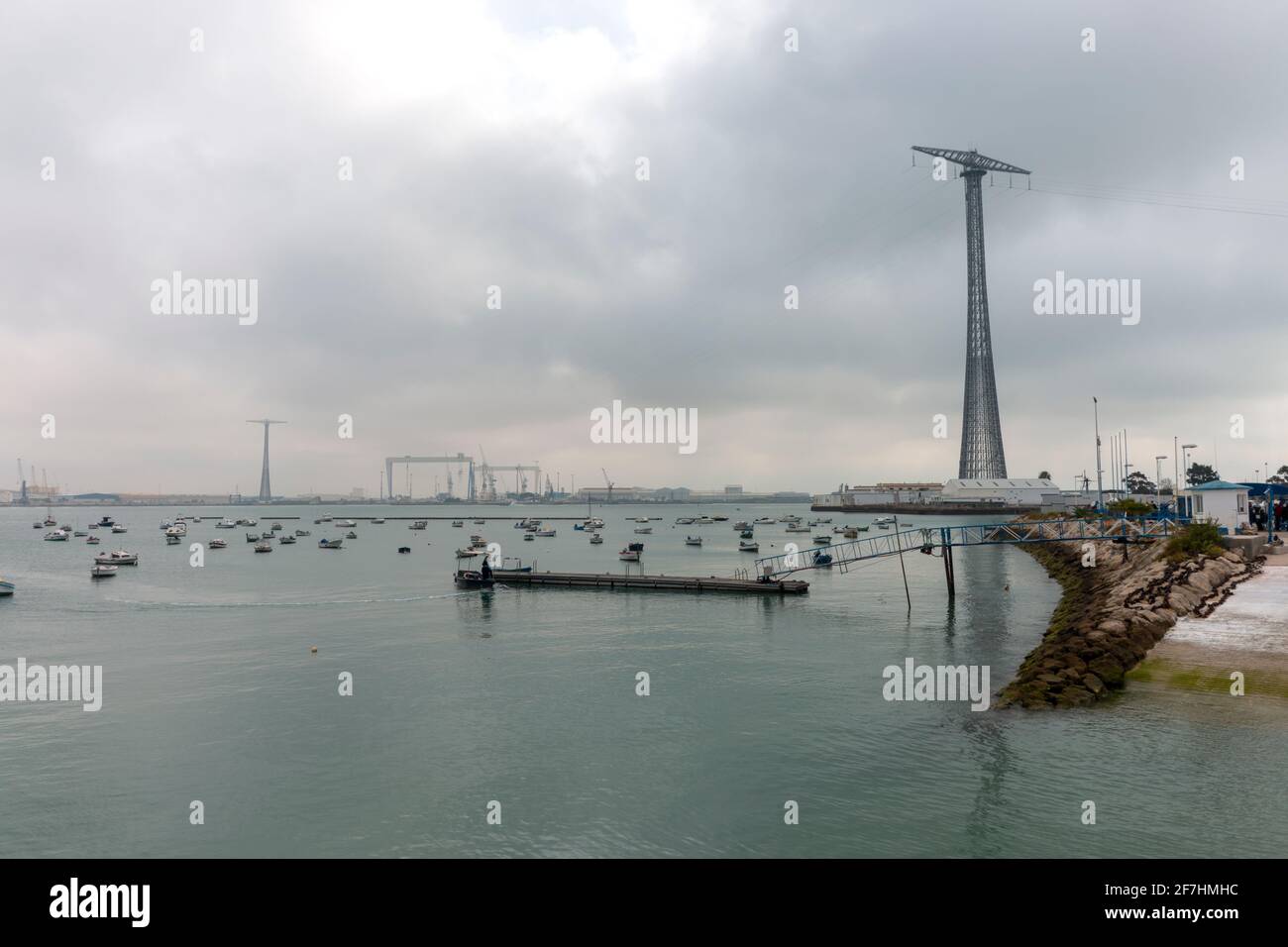 Paesaggio con piccole barche nella baia di Cadice su una giornata nuvolosa con un'enorme torre di comunicazione nel sfondo Foto Stock