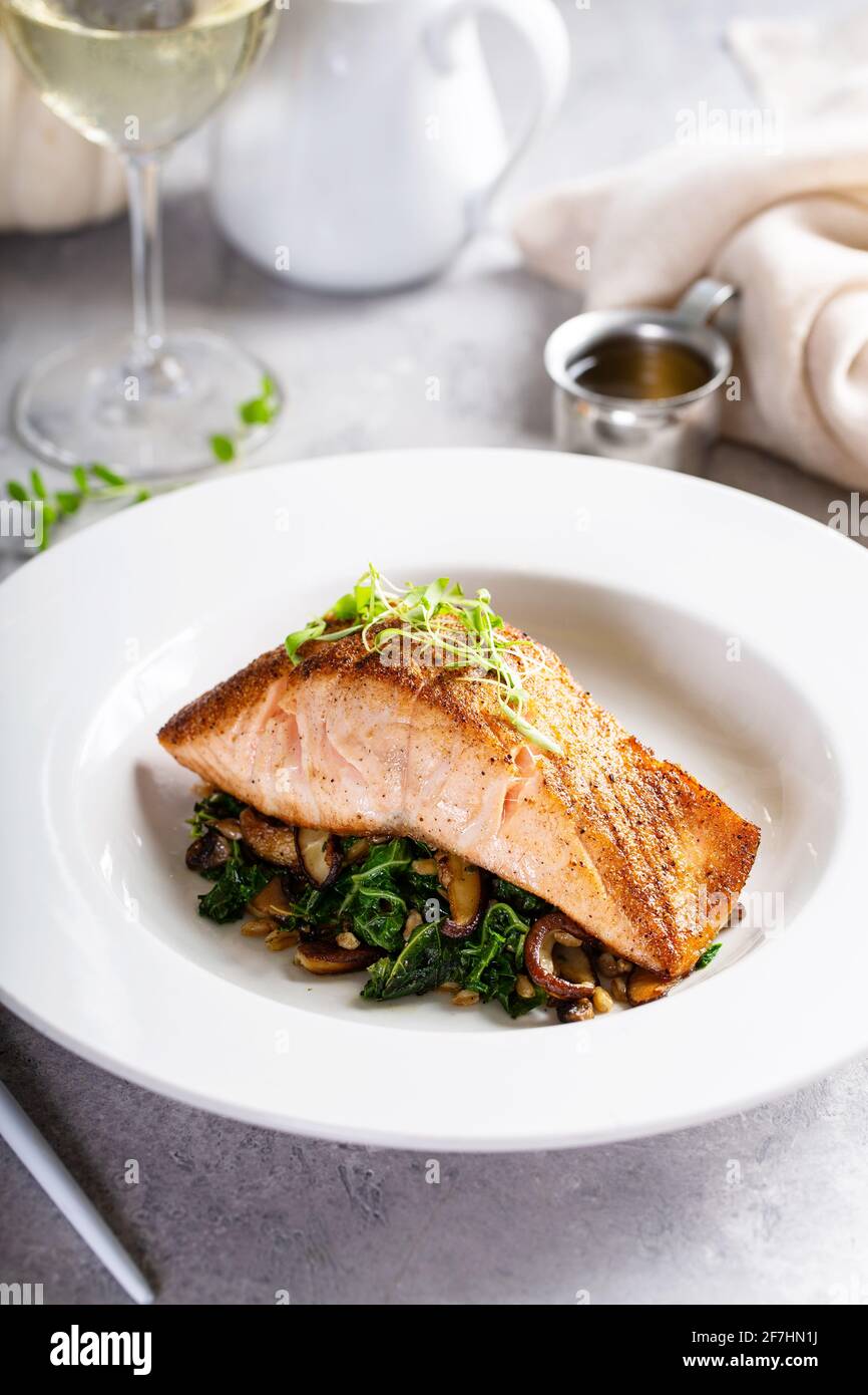 Filetto di salmone servito con verdure saltate e funghi Foto Stock