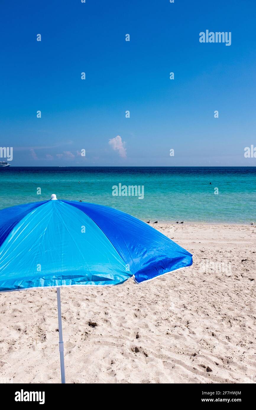 Un ombrellone blu incorniciato contro le acque azzurre dell'Atlantico al largo di South Beach, Miami Beach, Florida Foto Stock