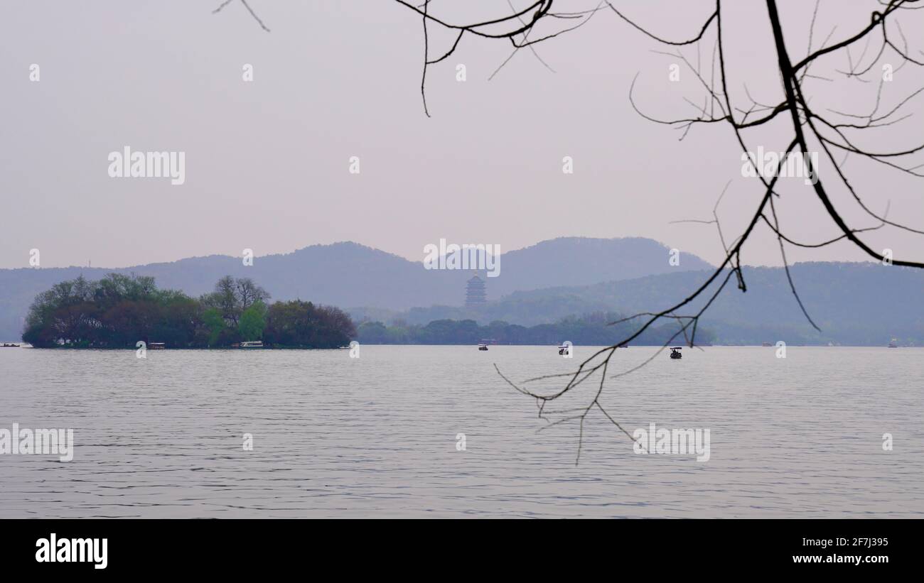 Piccola isola sul Lago Ovest con montagne lontane. Foto Stock