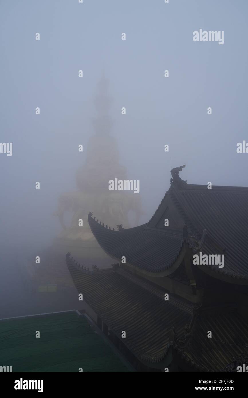 L'angolo del tempio buddismo con statue dorate di buddha dietro le quali è appena visibile a causa della nebbia pesante. Foto Stock