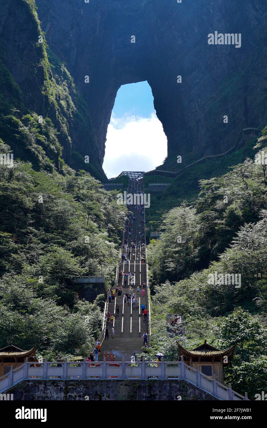 Un enorme buco formato dalla natura chiamato TianMenDong (alias Sky Hole) nel parco forestale nazionale di Zhangjiajie, con lunghi gradini di fronte. Foto Stock