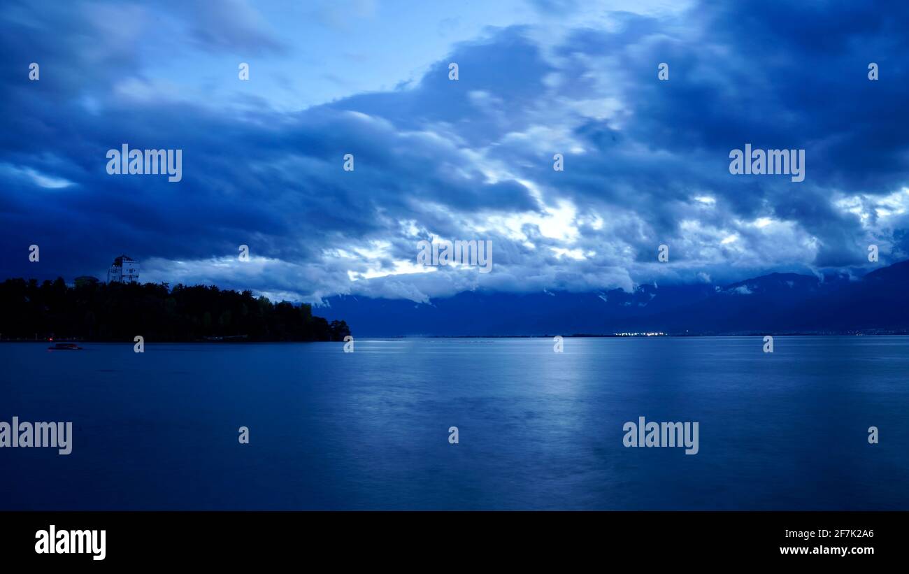 Lago di Erhai a Dali con cielo nuvoloso con cielo blu durante la notte, con un'isola lontana. Foto Stock