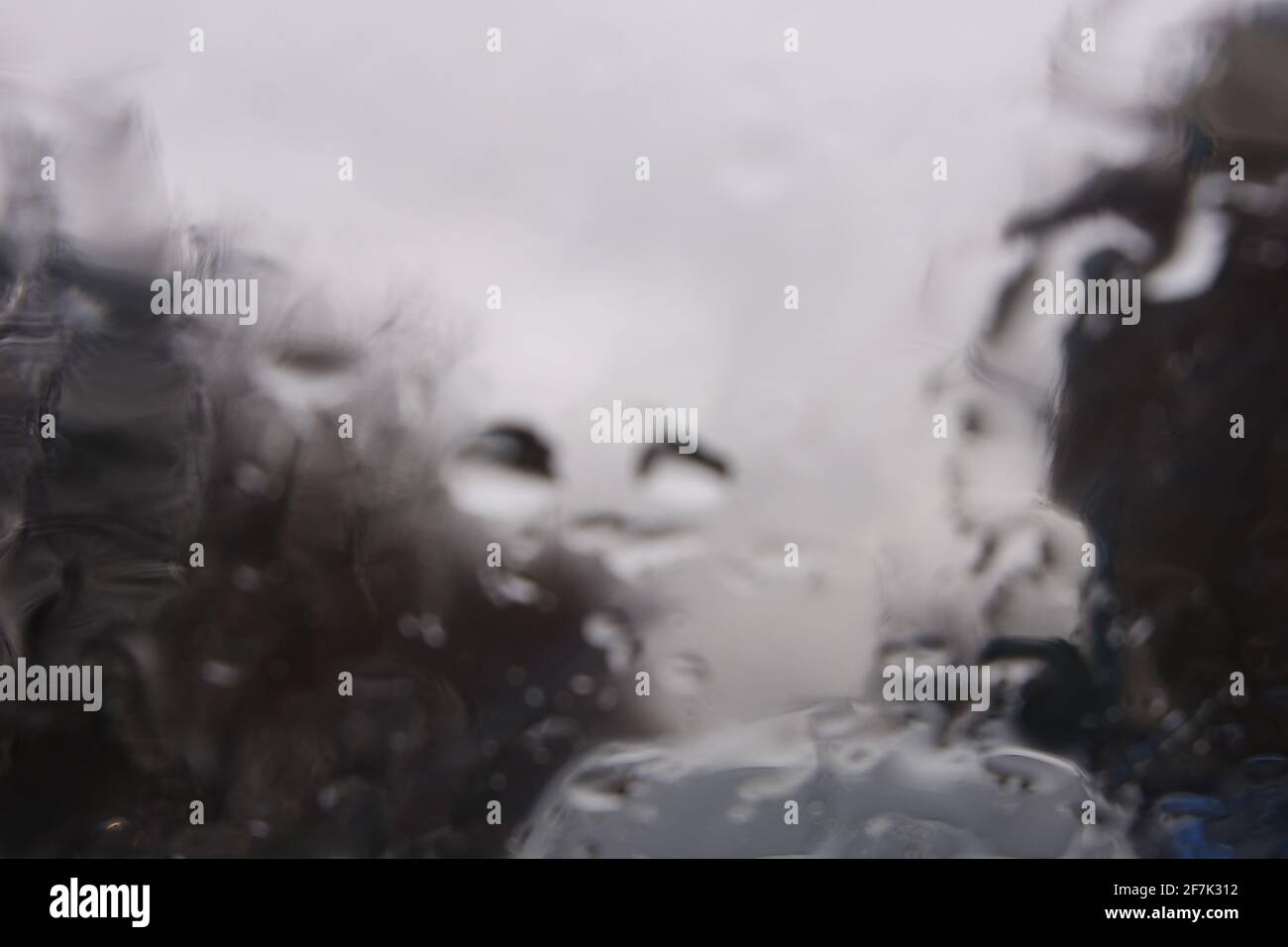 Gocce d'acqua sulla finestra in un giorno piovoso, Trees Roadside Foto Stock