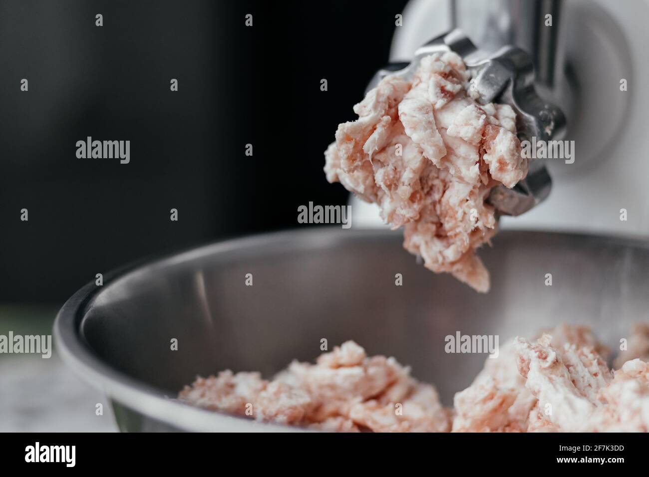 Caduta di carne da un macinacaffè primo piano con posto per il tuo testo. Carne tritata. Foto Stock