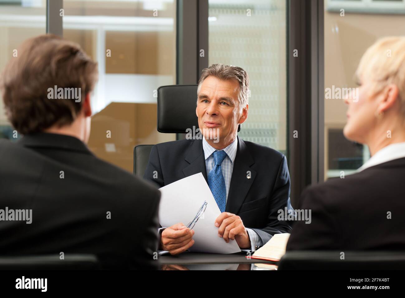 Coppia avvocato o di un notaio con i clienti nel suo ufficio in una riunione Foto Stock