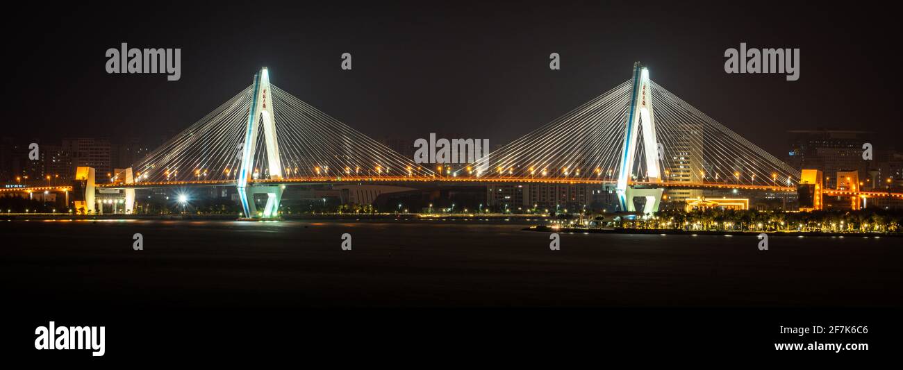 Vista panoramica del ponte secolo simbolo della città di Haikou illuminata di notte in Haikou Hainan Cina ( traduzione : ponte del secolo ) Foto Stock