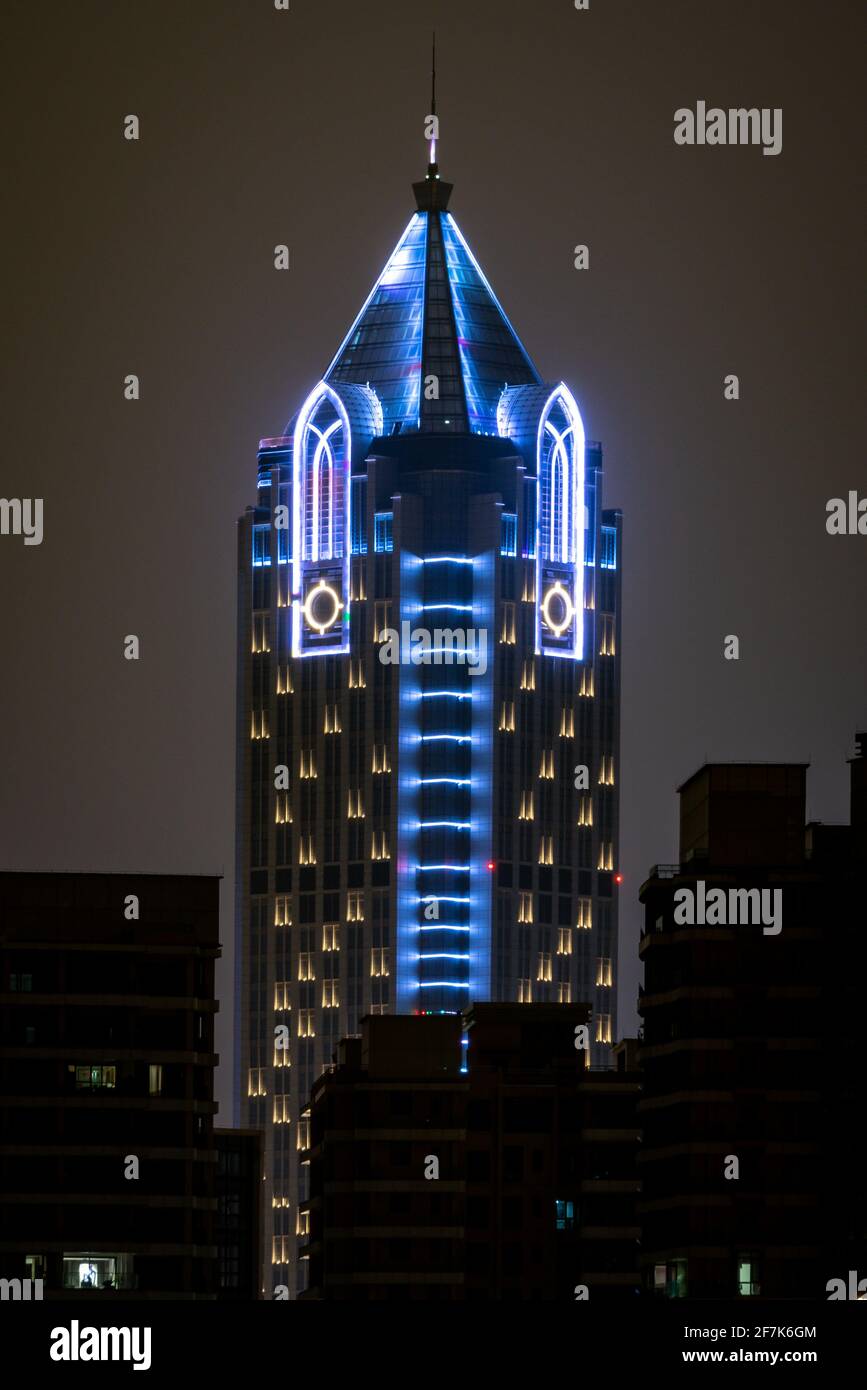 Haikou Cina, 21 marzo 2021: Vista verticale della cima del Landmark Tower edificio illuminato di notte un grattacielo alto 260 m in Haikou Hainan CH Foto Stock
