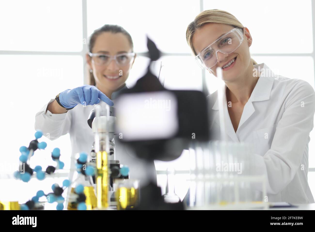Donne scienziati che conducono esperimenti chimici e riprese con la fotocamera. Concetto di blogging scientifico Foto Stock