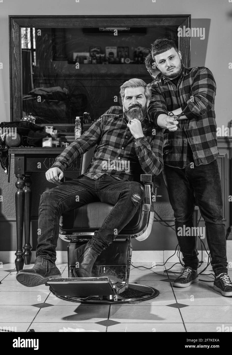 Cura della barba. Servizi di barbiere. Look perfetto. Capelli del viso. Bello hipster. Persona seduta su sedia idraulica. Visita il parrucchiere. Manutenzione Foto Stock