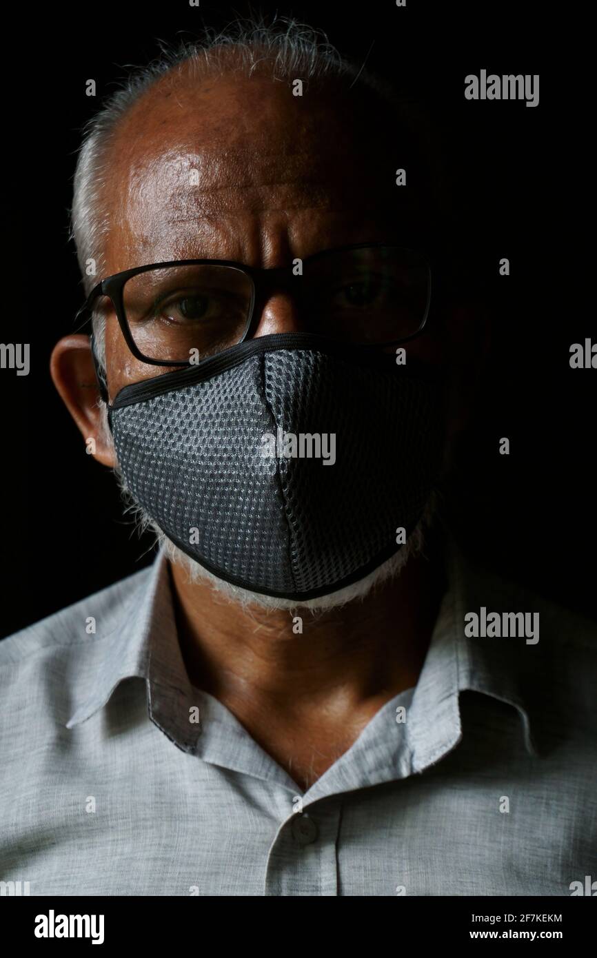 Ritratto di un uomo indiano di 60 anni che indossa una maschera Foto Stock