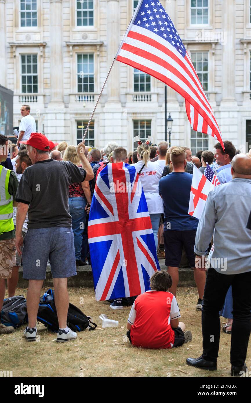 Manifestanti e attivisti in un raduno "Free Tommy Robinson" con Union Jack, bandiere inglesi e statunitensi, Whitehall, Londra Foto Stock