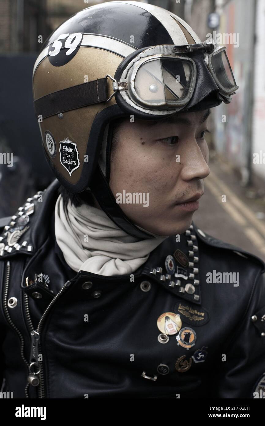 Primo piano ritratto di giovane biker, cafe racer che indossa una giacca in  pelle, sciarpa bianca e casco da moto con occhiali a Londra, Regno Unito  Foto stock - Alamy