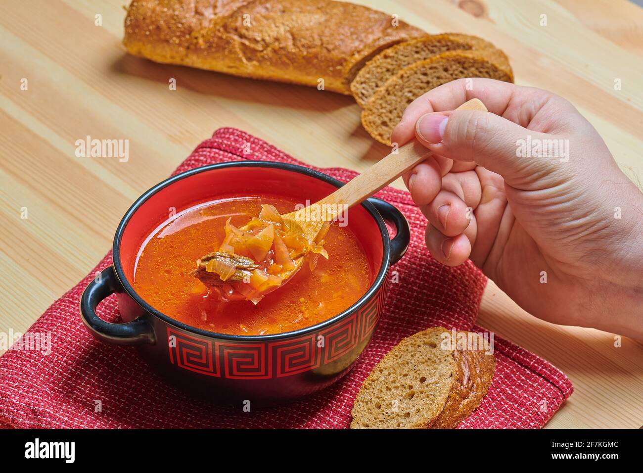 zuppa in un recipiente rosso con pane Foto Stock