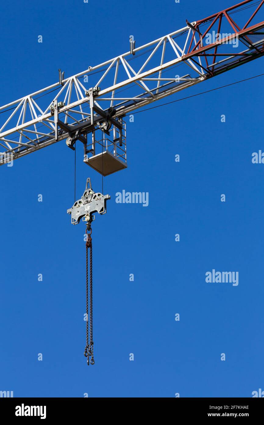 Dettagli della gru di costruzione sullo sfondo del cielo blu. Catena della gru e sistema a puleggia. Foto scattata in una giornata di sole. Foto Stock