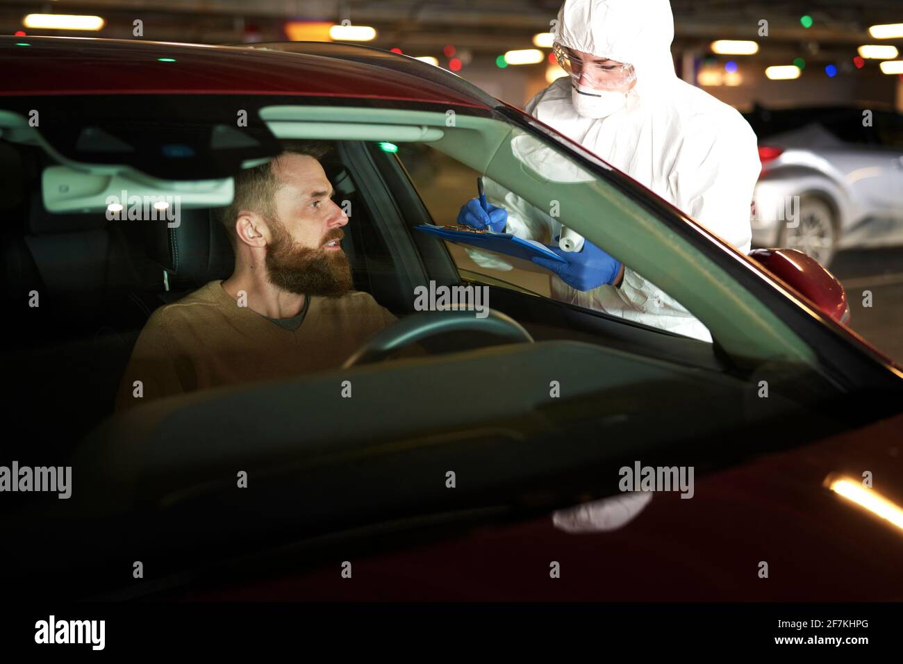 Driver durante la procedura di test PCR drive-through del coronavirus Foto Stock