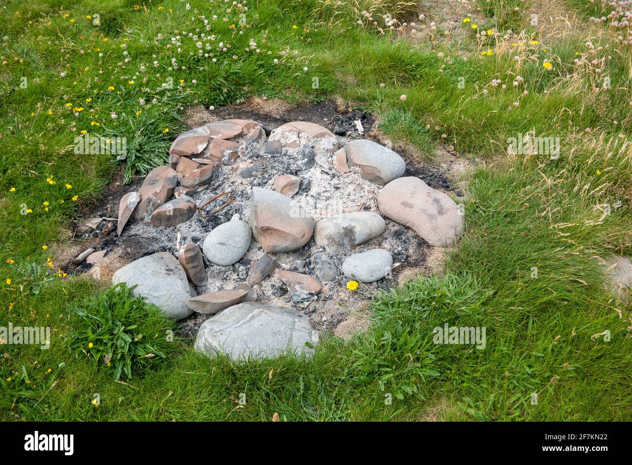 I resti bruciati di un fuoco o di un barbecue in erba nel North Devon Coast National Landscape, in Inghilterra. Foto Stock