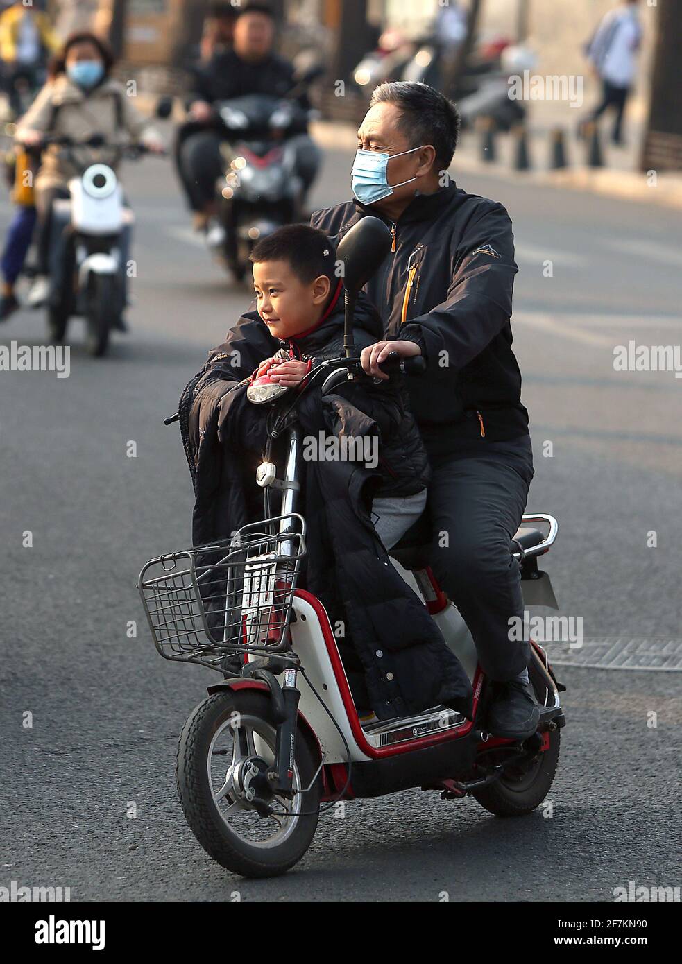 Pechino, Cina. 8 aprile 2021. Un padre preleva il figlio dalla scuola di Pechino giovedì 8 aprile 2021. L'attuale censimento cinese, effettuato ogni dieci anni, dovrebbe mostrare un ulteriore calo della percentuale di giovani nella sua popolazione in rapido invecchiamento, come l'aumento dei costi di vita e l'avversione a far passare i bambini tra le coppie urbane a un paese più vicino ad una crisi demografica. Il tasso di natalità in Cina ha continuato a diminuire. Foto di Stephen Shaver/UPI Credit: UPI/Alamy Live News Foto Stock