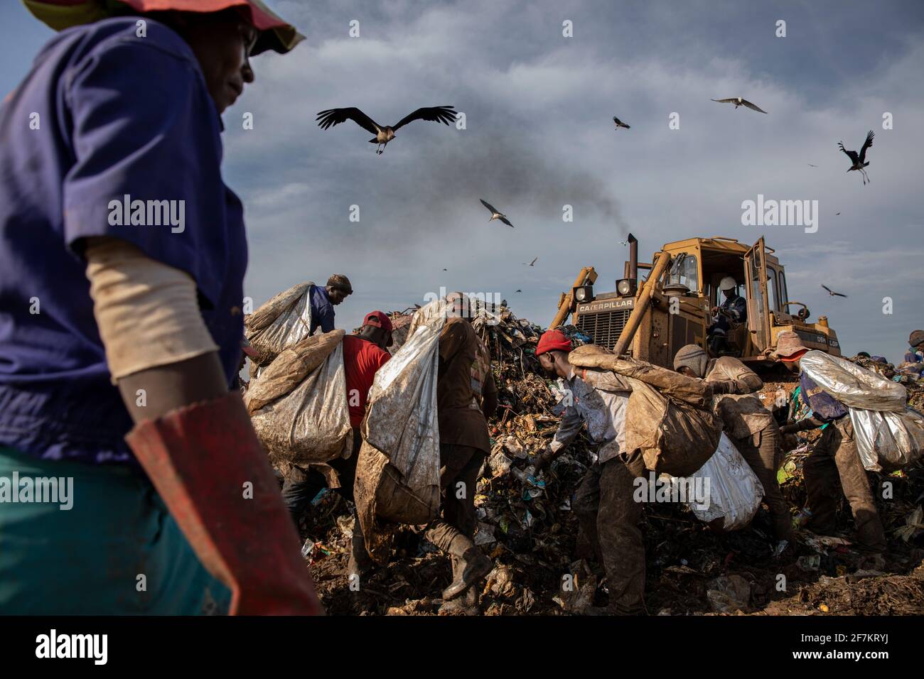 KAMPALA, UGANDA: Gruppi di lavoratori lavorano attraverso i mucchi di rifiuti. IMMAGINI che mostrano lavoratori ugandesi esausti che vagliano la t montagnosa Foto Stock