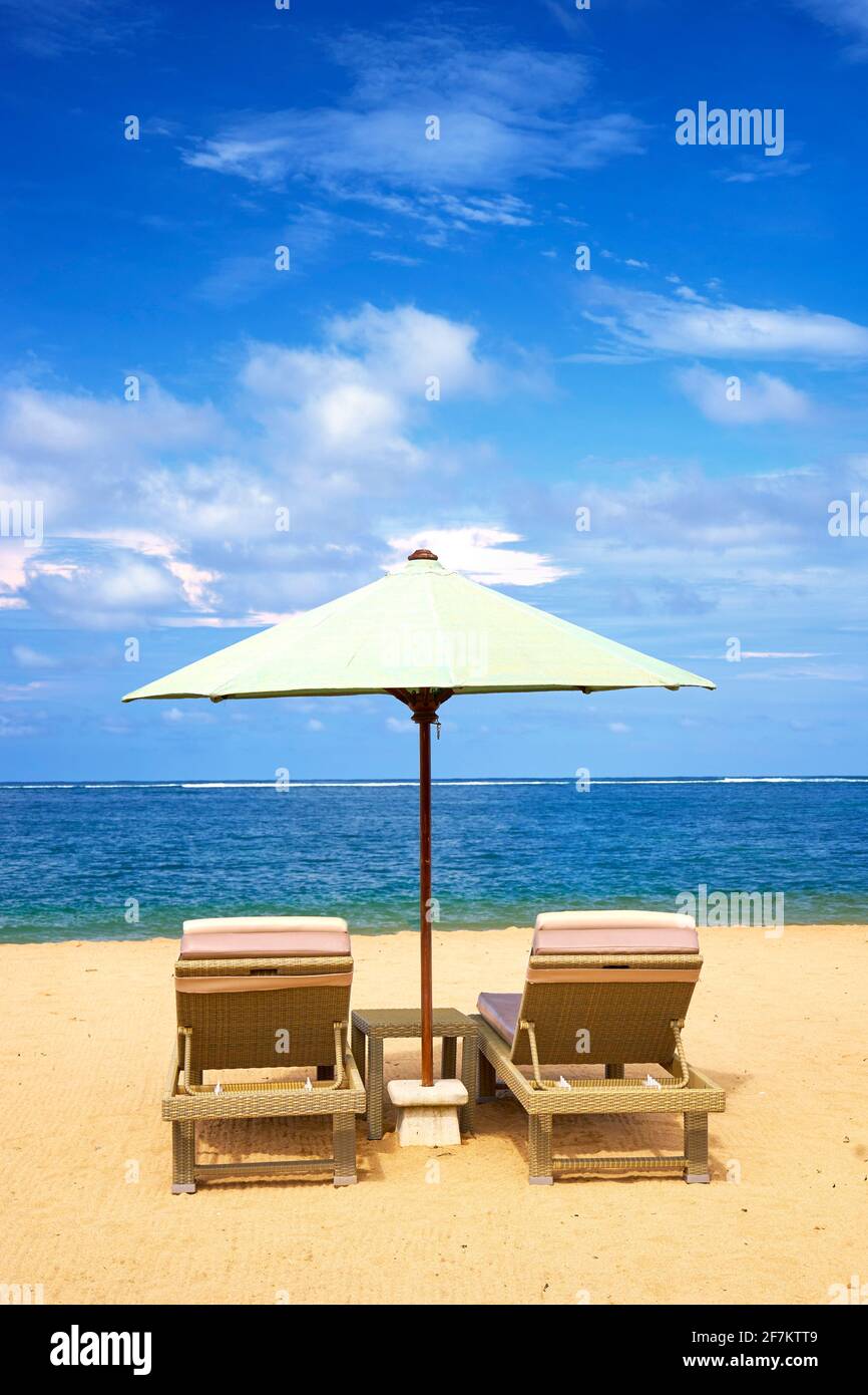 Sedie a sdraio con ombrellone sulla spiaggia di Sanur, Bali, Indonesia Foto Stock
