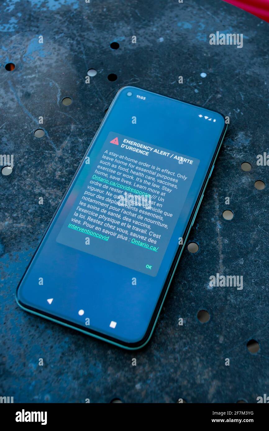 Ottawa, Ontario, Canada - 8 aprile 2021: Lo schermo di uno smartphone visualizza un avviso di emergenza che informa i residenti dell'Ontario di un ordine di soggiorno a casa in vigore Foto Stock