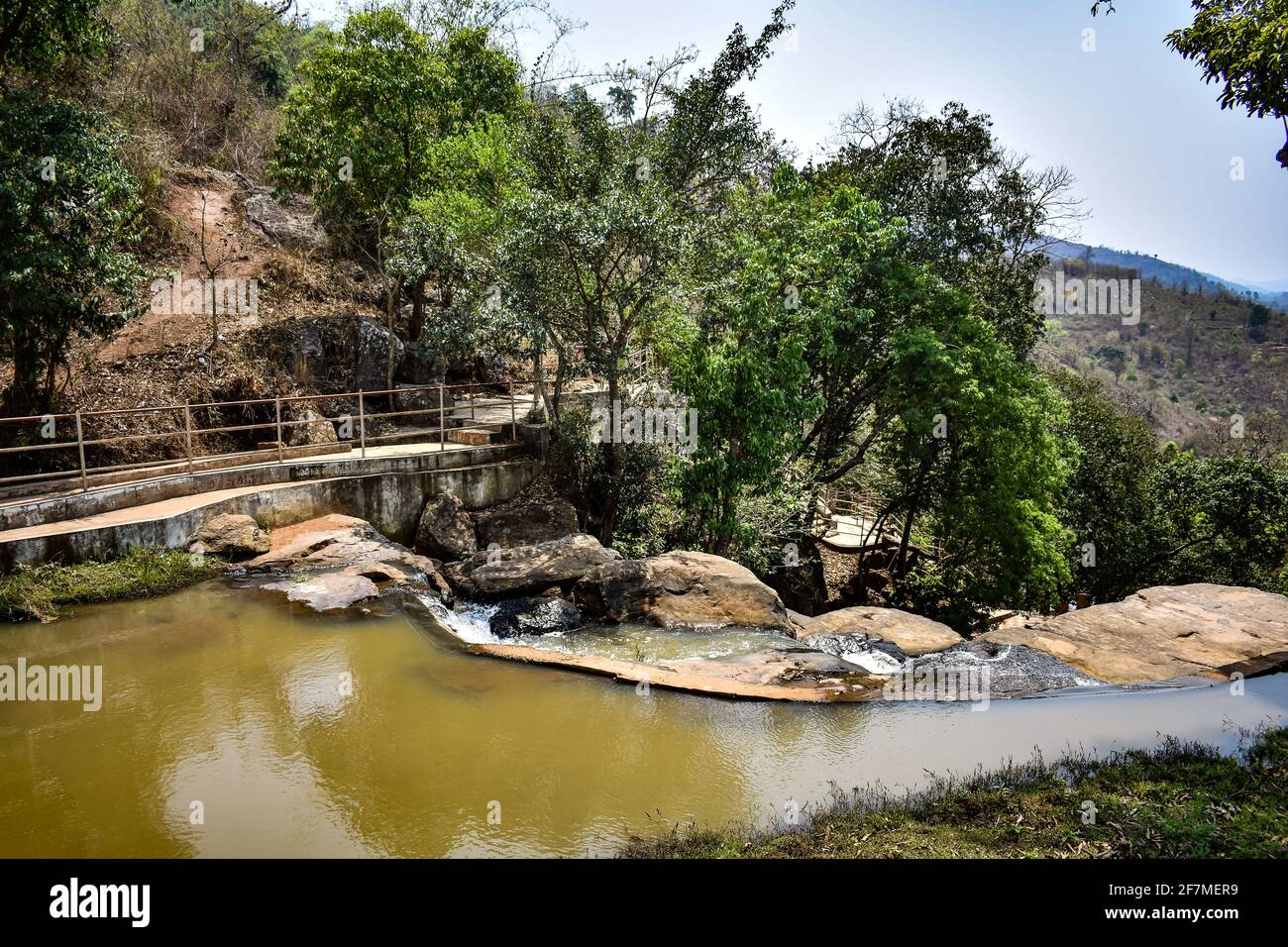 Piccolo serbatoio d'acqua in montagna di pietra con ponte per la comunicazione da un lato all'altro. Foto Stock