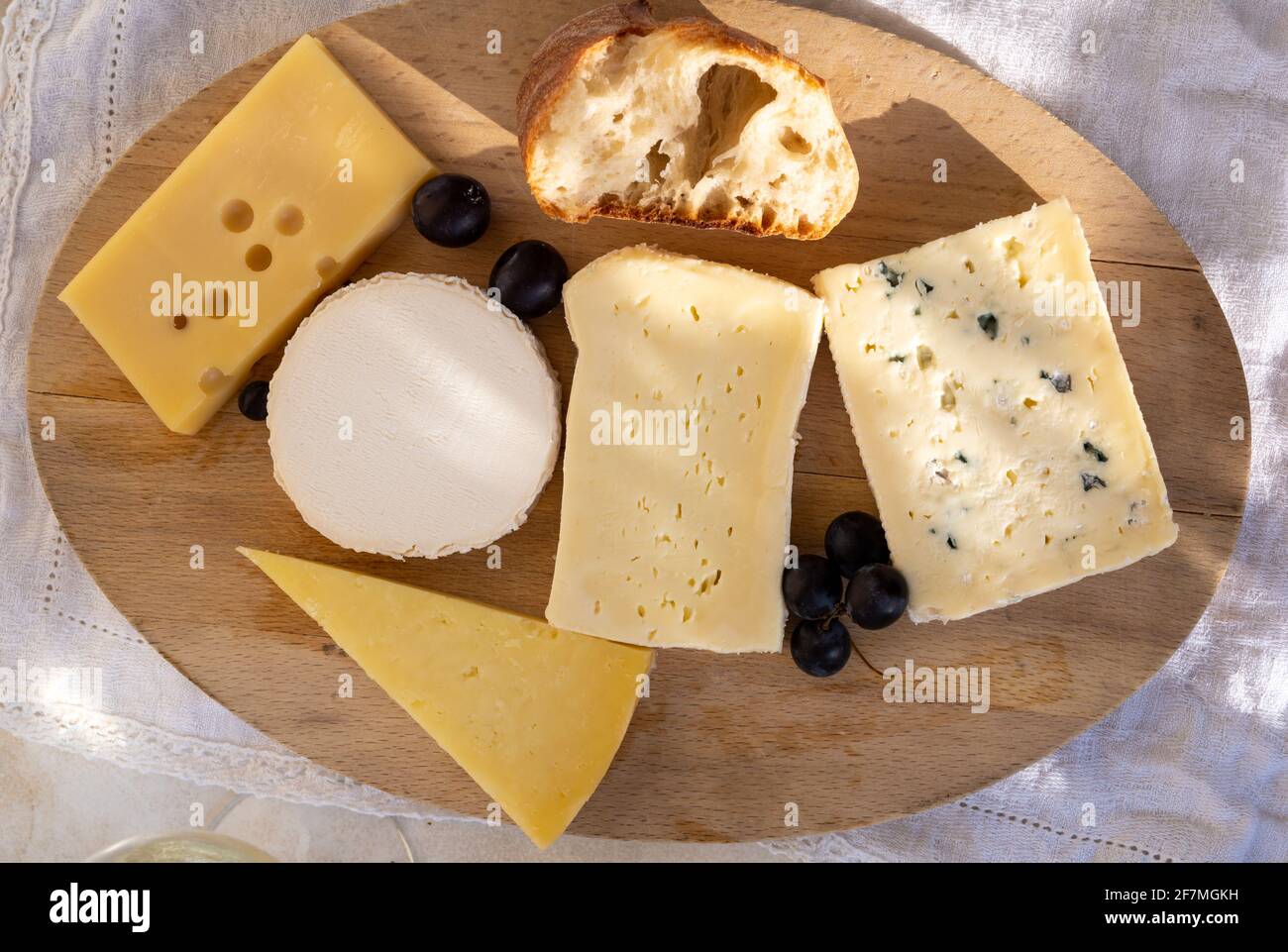 Collezione di formaggi francesi su tavola di marmo, emmental, carre de aurillac, petit cantal AOP Jeune, buche chevre e brie Foto Stock