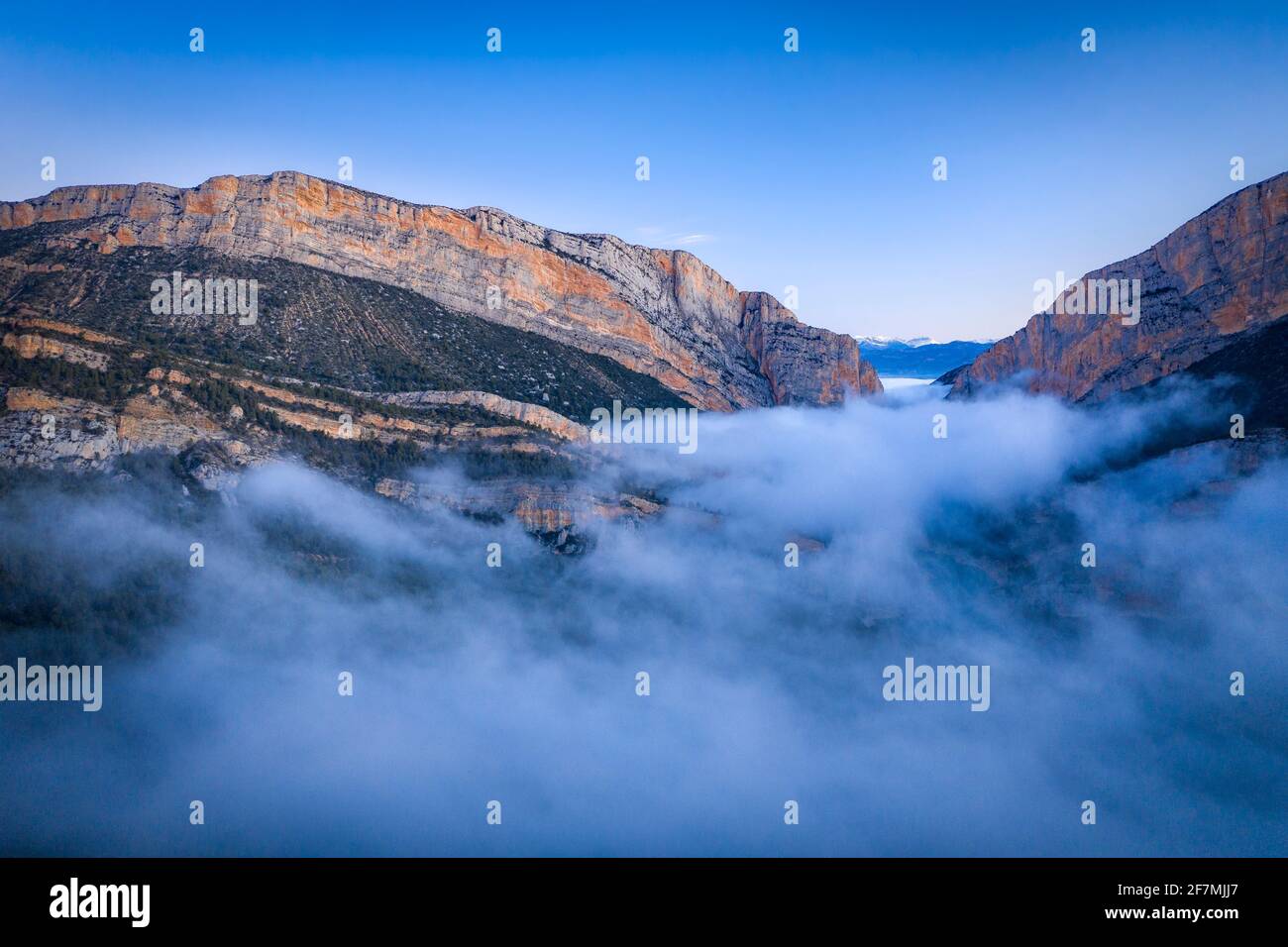 La gola del Congost de Mont-rebei e l'eremo di Santa Quiteria si affacciano in un'alba in nebbia d'inverno (Montfalcón, Aragona, Spagna, Pirenei) Foto Stock