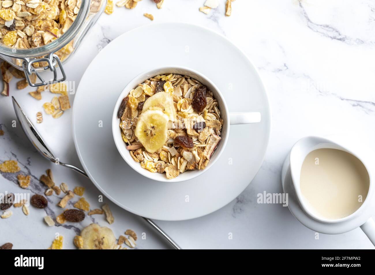 Ciotola del latte con cereali per la colazione a grani interi e caraffa di  latte. Muesli con frutta secca e frutta secca. Con spazio per la copia. Su  sfondo chiaro Foto stock -