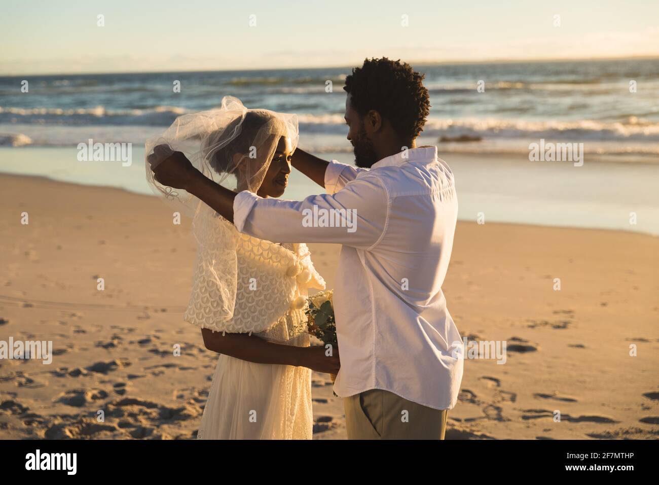 Coppia afroamericana innamorata sposarsi sulla spiaggia Foto Stock