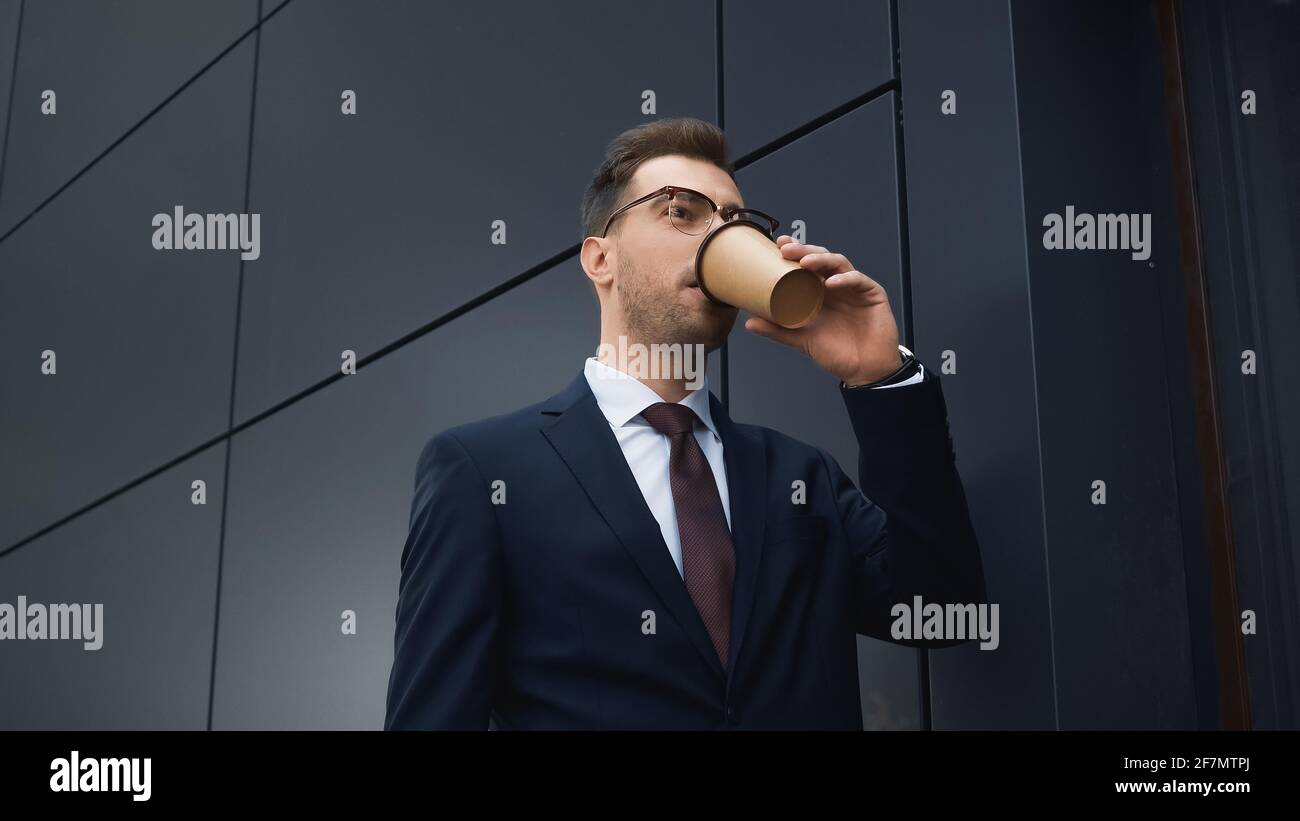 uomo d'affari che beve caffè per andare fuori, immagine di scorta Foto Stock