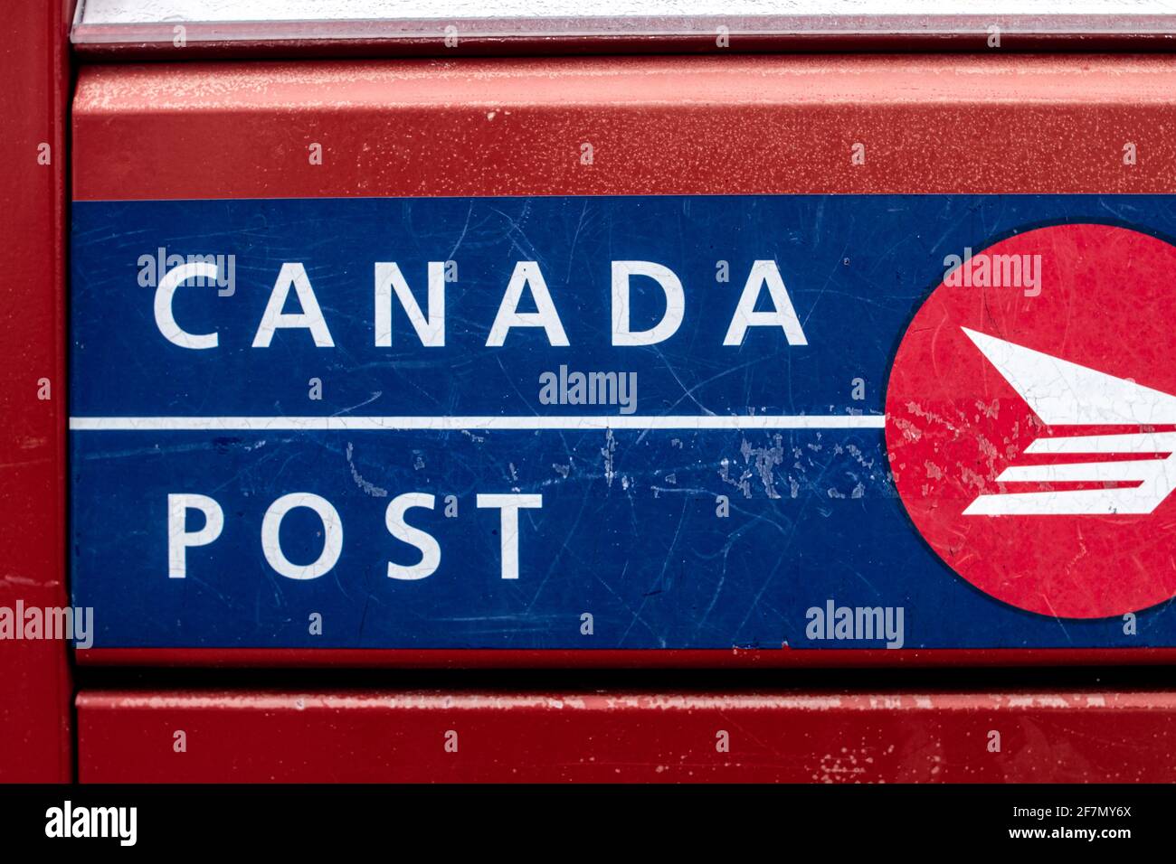 Londra, Ontario, Canada - Febbraio 15 2021: Rosso, blu e bianco Canada post-scatola di lettere in metallo, scatto fresco e primo piano del logo. Foto Stock