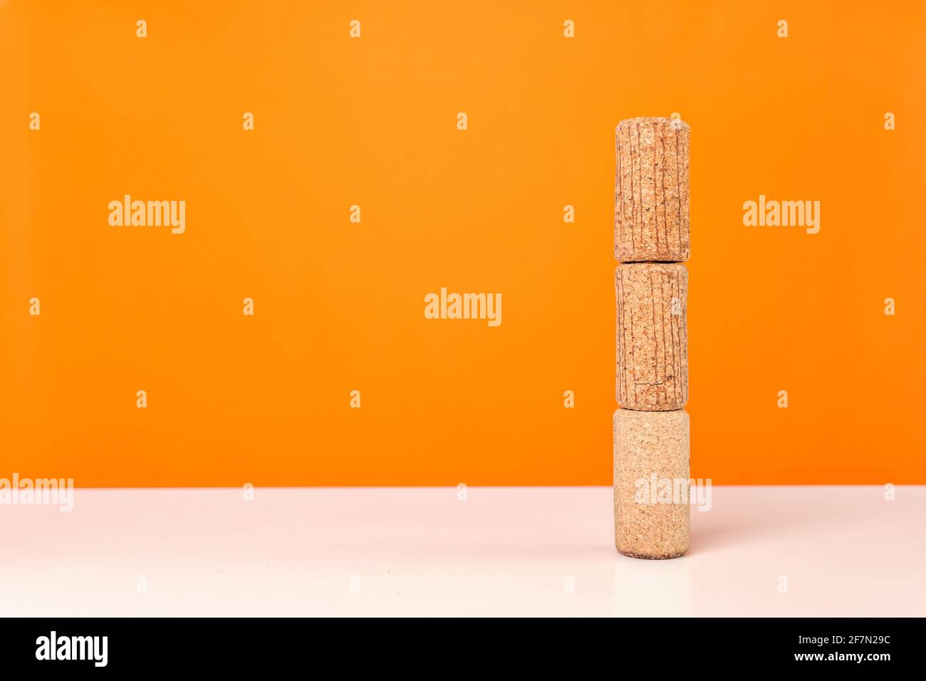 Tappi di vino su tavola bianca su sfondo arancione brillante. Colori vivaci e minimalistici. Foto Stock